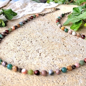 Peut inclure: Un collier de pierres pr&eacute;cieuses multicolores avec un fermoir en laiton. Le collier pr&eacute;sente une vari&eacute;t&eacute; de pierres, notamment du vert, du brun, du rouge et du rose.