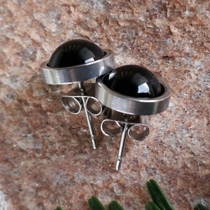 Peut inclure: Une paire de boucles d'oreilles à clous en pierres précieuses noires avec des montures argentées. Les boucles d'oreilles ont un poteau et un fermoir papillon.