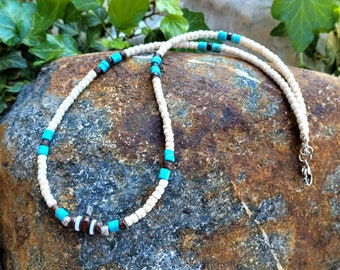 Surfer necklace made of predominantly cream-colored coconut beads and accents