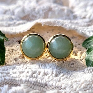 Peut inclure: Une paire de boucles d'oreilles clous en or avec des accents de pierres précieuses vertes rondes.