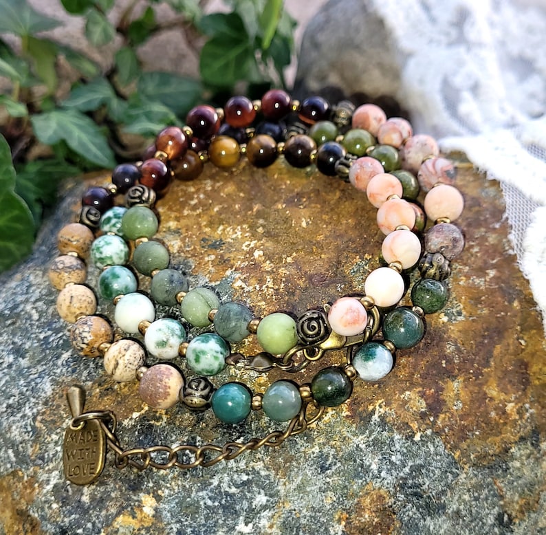 May include: Multi-colored gemstone bracelet with a brass clasp and a charm that says "Made with Love".