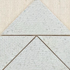 Puede incluir: Cinco azulejos triangulares de cerámica blanca dispuestos en un patrón para formar un triángulo más grande.