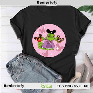 May include: Black t-shirt with a cartoon chameleon in a purple dress and Mickey Mouse ears, holding donuts. The design is set in a pink circle with Mickey Mouse shapes and stars. The shirt is shown with denim shorts and high heels.