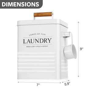 May include: White metal laundry bin with a wooden handle and a scoop on the side. The bin is 9 inches tall, 7 inches wide, and 5.9 inches deep. It has the text "Loads of Fun Laundry Wash Dry Fold Repeat" printed on the front.