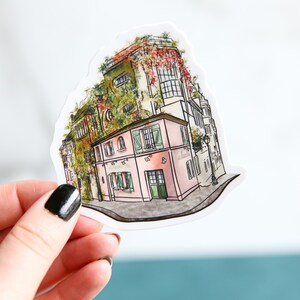 May include: A watercolor illustration of a pink building with green shutters and a green roof. The building is surrounded by greenery and is set against a white background.