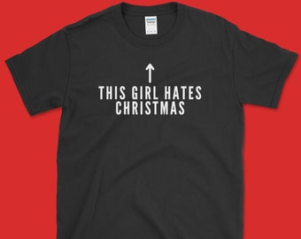Könnte beinhalten: Schwarzes T-Shirt mit weißem Text, der "This girl hates Christmas" lautet, und einem nach oben zeigenden Pfeil.