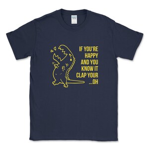 Peut inclure: Un t-shirt bleu marine avec un dinosaure jaune en dessin anim&eacute; et le texte "If you're happy and you know it clap your...oh".