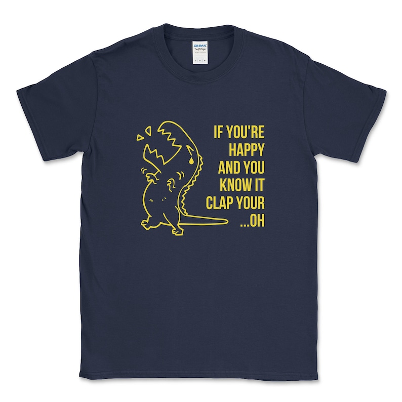 Peut inclure: Un t-shirt bleu marine avec un dinosaure jaune en dessin anim&eacute; et le texte "If you're happy and you know it clap your...oh".
