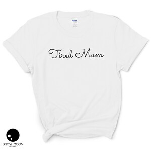 May include: White t-shirt with the text "Tired Mum" in black cursive writing.