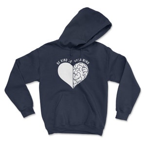 May include: Navy blue hoodie with a white heart design. The heart is split in half, with one side being a brain and the other side being blank. The text "Be kind to your mind" is written around the heart.