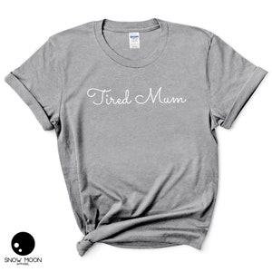 May include: Gray t-shirt with the text "Tired Mum" in white cursive writing.