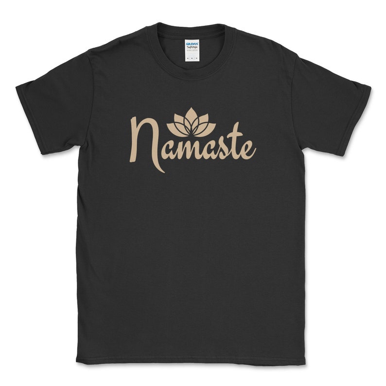 K&ouml;nnte beinhalten: Schwarzes T-Shirt mit dem Wort "Namaste" in beiger Schrift, gekr&ouml;nt von einer Lotusblumen-Grafik. Das Rundhals-T-Shirt ist aus Baumwolle. Das Gildan-Markenetikett ist am Halsausschnitt sichtbar.