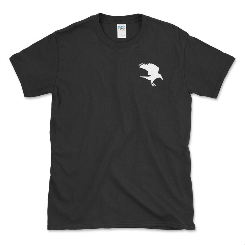 May include: Black t-shirt featuring a white silhouette of a bird in flight. The bird design is on the upper left chest area of the shirt. The shirt is a crew neck style and appears to be made of cotton.