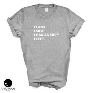 May include: A heather grey t-shirt with the text "I CAME I SAW I HAD ANXIETY I LEFT."