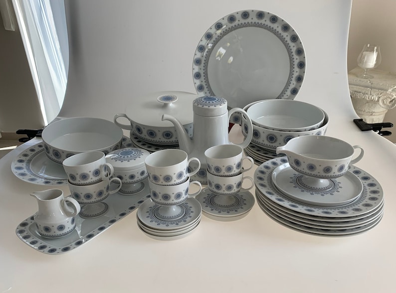 K&ouml;nnte beinhalten: Ein wei&szlig;es und blaues Geschirr-Set mit Teekanne, Milchk&auml;nnchen, Zuckerdose, Tassen, Untertassen, Tellern und Servier-Schalen.
