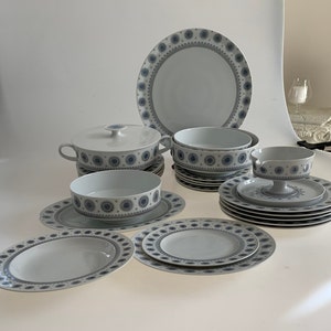 K&ouml;nnte beinhalten: Ein Set aus wei&szlig;em Porzellan-Geschirr mit einem blauen und grauen Blumenmuster. Das Set enth&auml;lt eine gro&szlig;e Platte, Schalen und Teller.