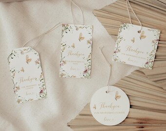 Puede incluir: Cuatro etiquetas de regalo de papel blanco con cordeles, con ilustraciones en acuarela de mariposas y flores silvestres. El texto dice Thank you for showering us with love. El conjunto incluye dos etiquetas rectangulares, una cuadrada y una circular.