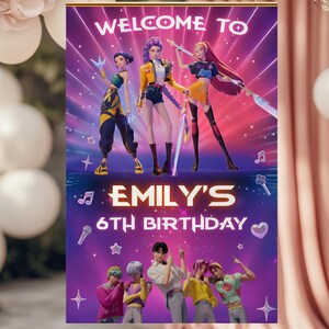 May include: A purple birthday banner with the text "Welcome to Emily's 6th Birthday." The banner features animated figures and musical notes. The background has a purple and pink color scheme.
