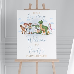 May include: A white sign on a wooden easel with the text "It's a boy story" and "Welcome to Emily's Baby Shower". The sign features cartoon characters from the Toy Story movie. The background is a light blue with white clouds.