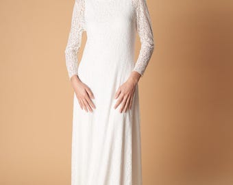 May include: A white lace maxi dress with long sleeves and a boat neckline. The dress is made of a delicate lace fabric and has a flowing silhouette.