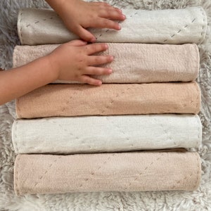 A child's hands rest on the soft natural cotton placemats