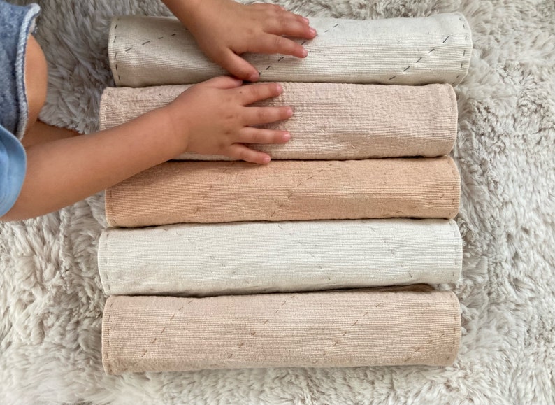A child's hands rest on the soft natural cotton placemats