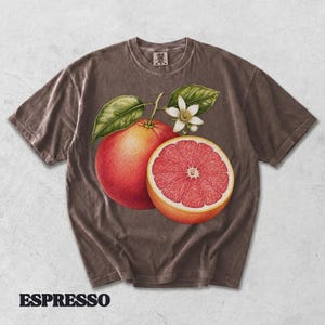 Puede incluir: Una camiseta marr&oacute;n de manga corta con un gr&aacute;fico de un pomelo entero, un pomelo cortado por la mitad y una flor blanca con hojas verdes. La palabra ESPRESSO est&aacute; impresa en negro debajo de la camiseta. La prenda tiene un cuello redondo.