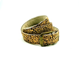 May include: A brown and black leopard print belt with a gold metal buckle.