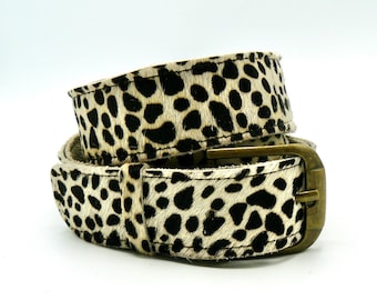 May include: A brown leather belt with a leopard print pattern and a brass buckle.