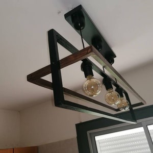 May include: A black and brown rectangular ceiling light fixture with five light bulbs. The fixture has a modern design with a wooden frame and black metal accents.