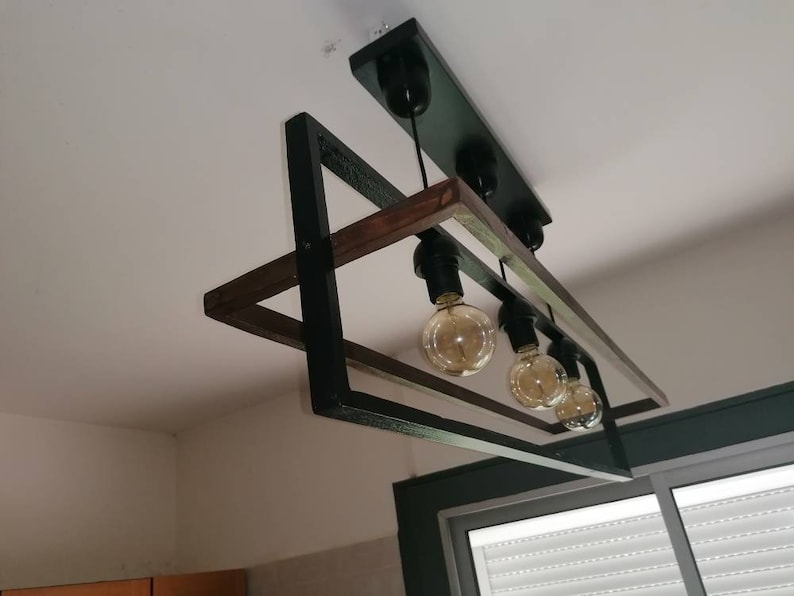 May include: A black and brown rectangular ceiling light fixture with five light bulbs. The fixture has a modern design with a wooden frame and black metal accents.