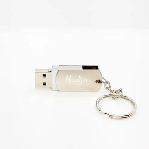 May include: Silver USB flash drive with a keychain. The drive is engraved with the text "Moonger" and a crescent moon.