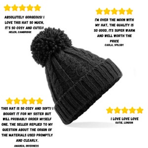 Peut inclure: Un bonnet en tricot noir avec un gros pompon sur le dessus. Le bonnet est en tissu &eacute;pais &agrave; c&ocirc;tes. Le bonnet est pr&eacute;sent&eacute; sur un fond blanc.