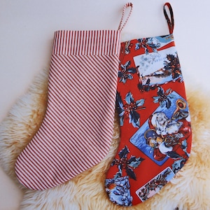 May include: Two Christmas stockings, one red with a vintage Christmas scene and the other red and white striped.