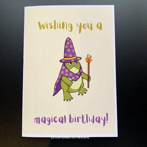 Un sorcier drôle de grenouille dessiné à la main vous souhaitant un cadeau d'anniversaire magique sur une carte A5
