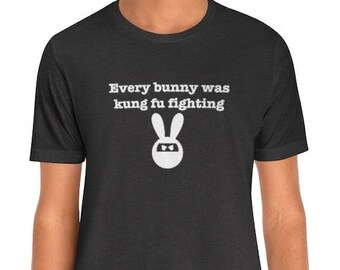 May include: A dark heather grey t-shirt with a white graphic of a bunny wearing a headband and the text "Every bunny was kung fu fighting".