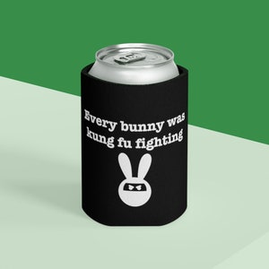 May include: Black and white can cooler with the text "Every bunny was kung fu fighting" and a white silhouette of a bunny wearing a ninja mask.