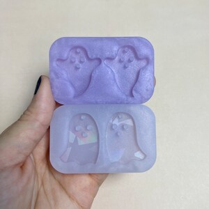 May include: A clear purple silicone mold with two ghost shapes. The mold is designed to create small, detailed ghost shapes.
