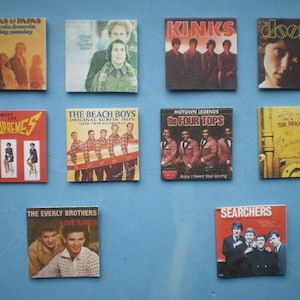 Puede incluir: Una colección de portadas de álbumes de vinilo vintage con artistas como The Mamas & Papas, The Beach Boys, The Kinks, The Doors, The Supremes, The Four Tops, The Rolling Stones, The Everly Brothers y The Searchers.