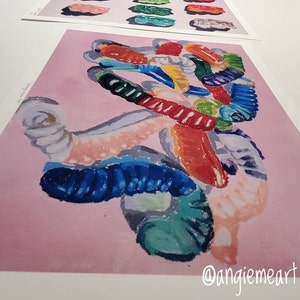 May include: A colorful abstract painting of gummy worms on a pink background. The painting is done in a loose, expressive style, with vibrant colors and bold brushstrokes. The gummy worms are arranged in a chaotic, yet pleasing, composition. The painting is signed "@angiemeart" in the lower right corner.