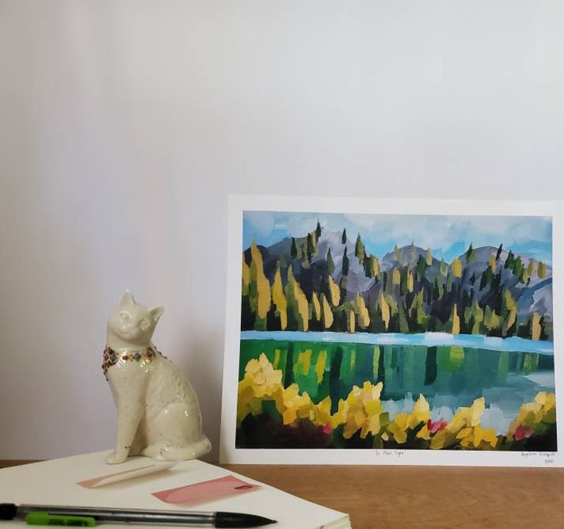 May include: A painting depicting a lake scene with a mountain range in the background. The lake is a bright blue and the mountains are a dark green. The trees are a mix of green and yellow. The painting is signed by the artist and dated 2021.