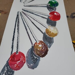 May include: A set of 10 colorful round lollipops on sticks arranged in a circle. The lollipops are red, orange, green, yellow, brown, and white.
