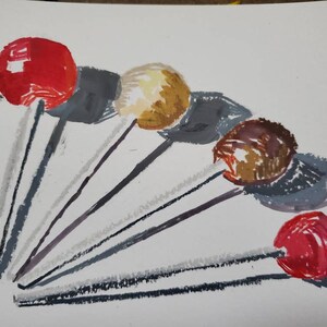 May include: A collection of seven colorful lollipops with gray sticks arranged in a fan shape on a white background.
