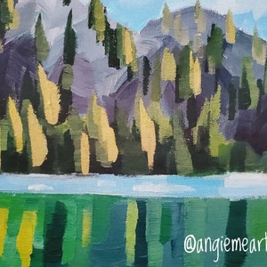 May include: A painting depicting a mountainous landscape with a lake in the foreground. The mountain is rendered in shades of purple, green, and yellow, with a blue sky above. The lake is a bright blue with green reflections. The artist's signature, "@angiemeart", is in the bottom right corner.