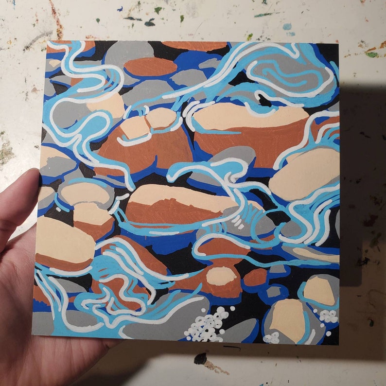 May include: Abstract painting of a river with blue and white water flowing over brown and beige rocks. The background is black.