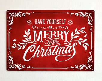 May include: A rectangular red metal sign featuring white decorative borders and the text "HAVE YOURSELF A MERRY little CHRISTMAS" in a mix of serif and script fonts. The design includes white snowflake icons and leafy vine accents in the corners.