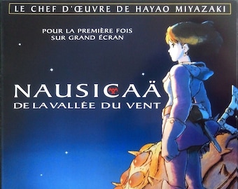 May include: A movie poster for the animated film "Nausicaä of the Valley of the Wind" by Hayao Miyazaki. The poster features a young woman with brown hair and a white shirt standing on a large, multi-legged creature against a dark blue sky with stars. The title of the film is written in large, white letters.