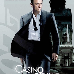 Puede incluir: Un póster de película para la película de James Bond Casino Royale. El póster presenta a Daniel Craig como James Bond con un esmoquin negro, de pie frente a un edificio con las palabras "Casino Royale" en él. El póster también presenta el texto "Le 22 Novembre" y "007".