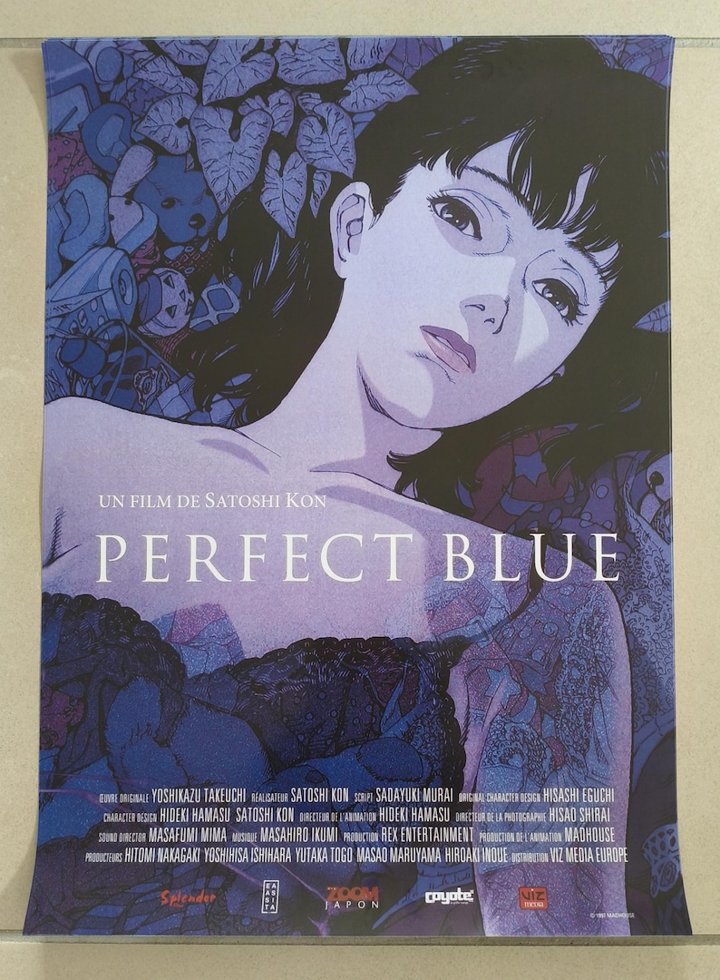 K&ouml;nnte beinhalten: Poster f&uuml;r den Animationsfilm "Perfect Blue" mit einer Frau mit dunklem Haar und einem nachdenklichen Ausdruck. Der Titel steht in gro&szlig;en wei&szlig;en Buchstaben, mit dem Filmtitel und den Credits in kleinerer Schrift. Die Farbpalette ist haupts&auml;chlich blau und lila.