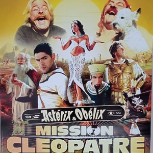 May include: A movie poster for the French comedy film Asterix & Obelix: Mission Cleopatra. The poster features a cast of actors including Gerard Depardieu, Jamel Debbouze, Alain Chabat, Monica Bellucci, Claude Rich, Christian Clavier, and Gerard Darmon. The poster is set against a backdrop of ancient Egypt with pyramids and desert landscapes.
